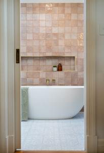 Modern bathroom with freestanding bath and blush wall tiles