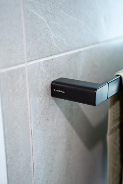 Close-up of matte black bathroom tapware on grey tiled wall