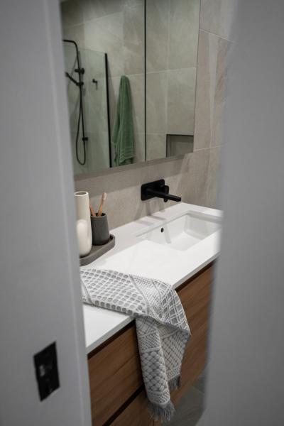 Modern bathroom vanity with white basin, mirror and black tapware