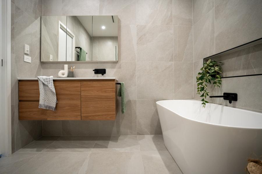 Modern bathroom with floating timber vanity, mirror cabinet and freestanding white bath
