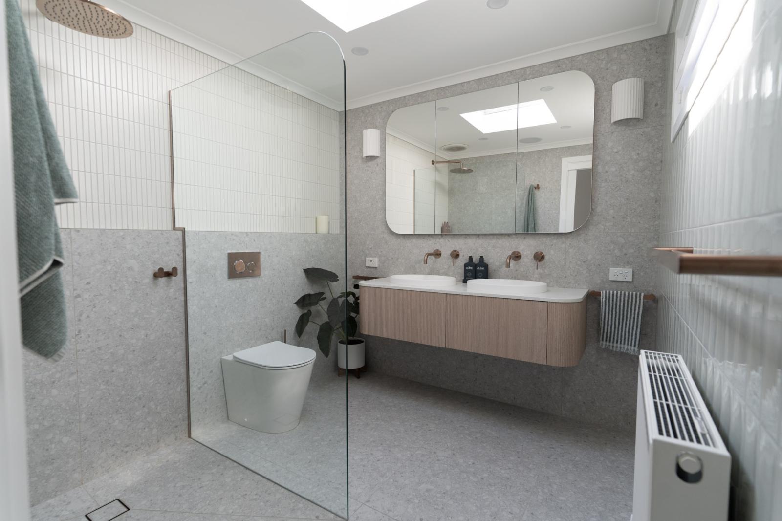 Modern grey bathroom with floating timber vanity, frameless shower and wall-hung toilet