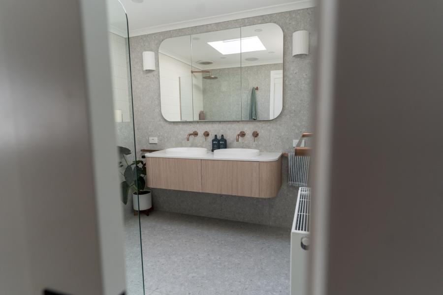 Modern bathroom with floating timber vanity, mirror cabinet and soft grey finishes