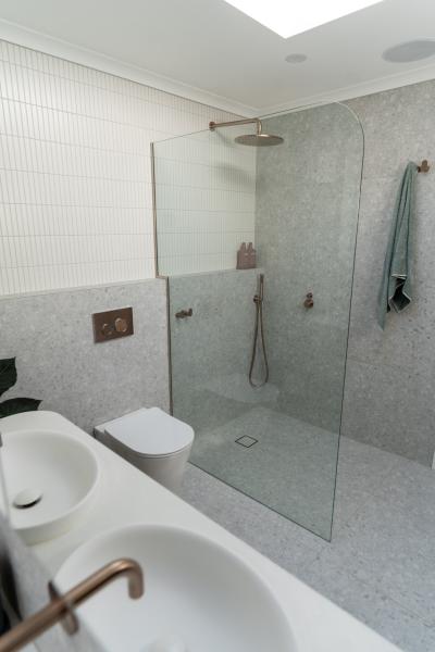 Modern white bathroom with frameless glass shower, wall-hung toilet and double vanity