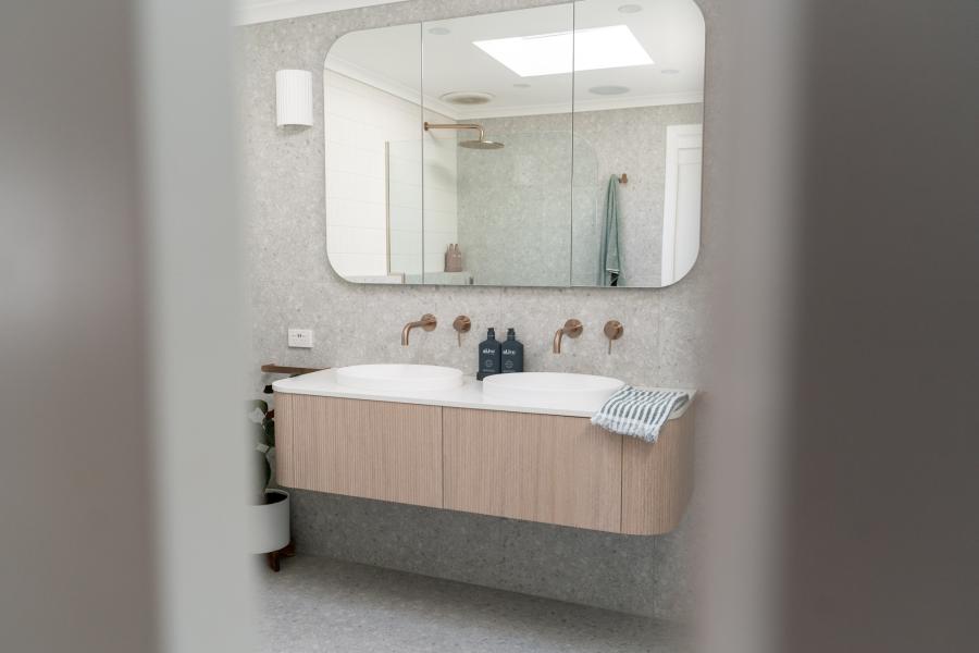 Modern bathroom vanity with twin basins, wall-mounted cabinetry and large mirror