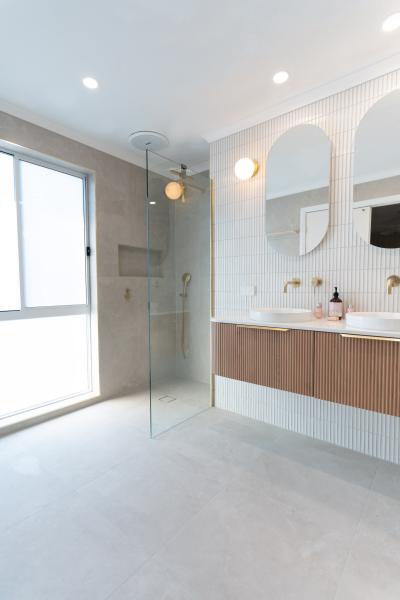 Bright modern bathroom with walk-in shower, floating timber vanity and arched mirrored cabinet