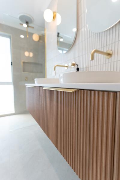 Modern bathroom vanity with fluted timber cabinetry, vessel basin and brushed brass tapware
