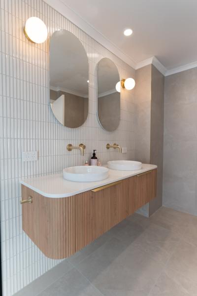 Modern bathroom with double vanity, ribbed timber cabinetry and arched mirrors