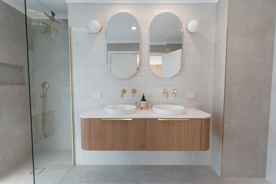 Modern bathroom with twin basins, arched mirrors, timber vanity and walk-in glass shower