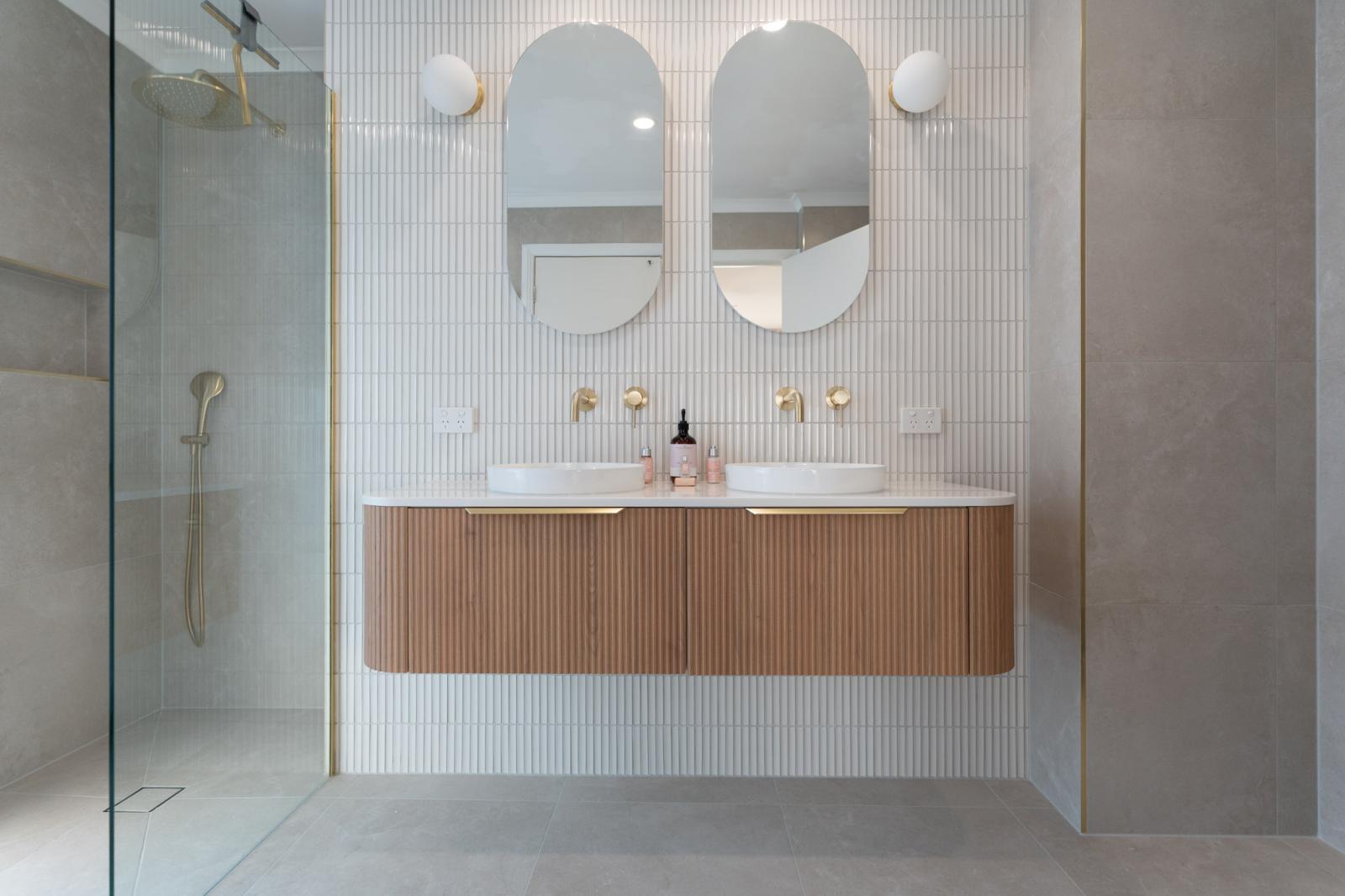 Modern bathroom with double oval mirrors, floating timber vanity and walk-in shower