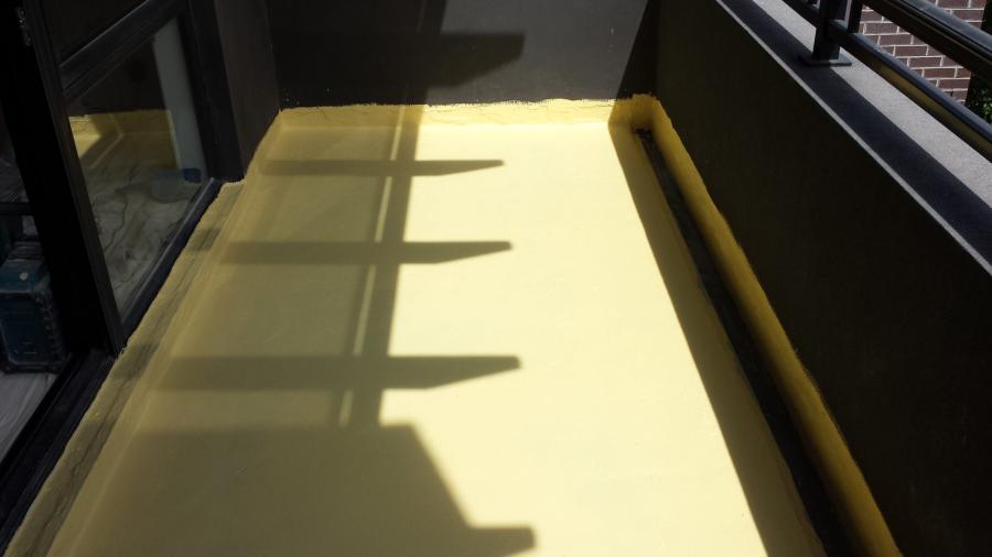 Sunlit balcony with smooth yellow waterproofed floor beside black railing