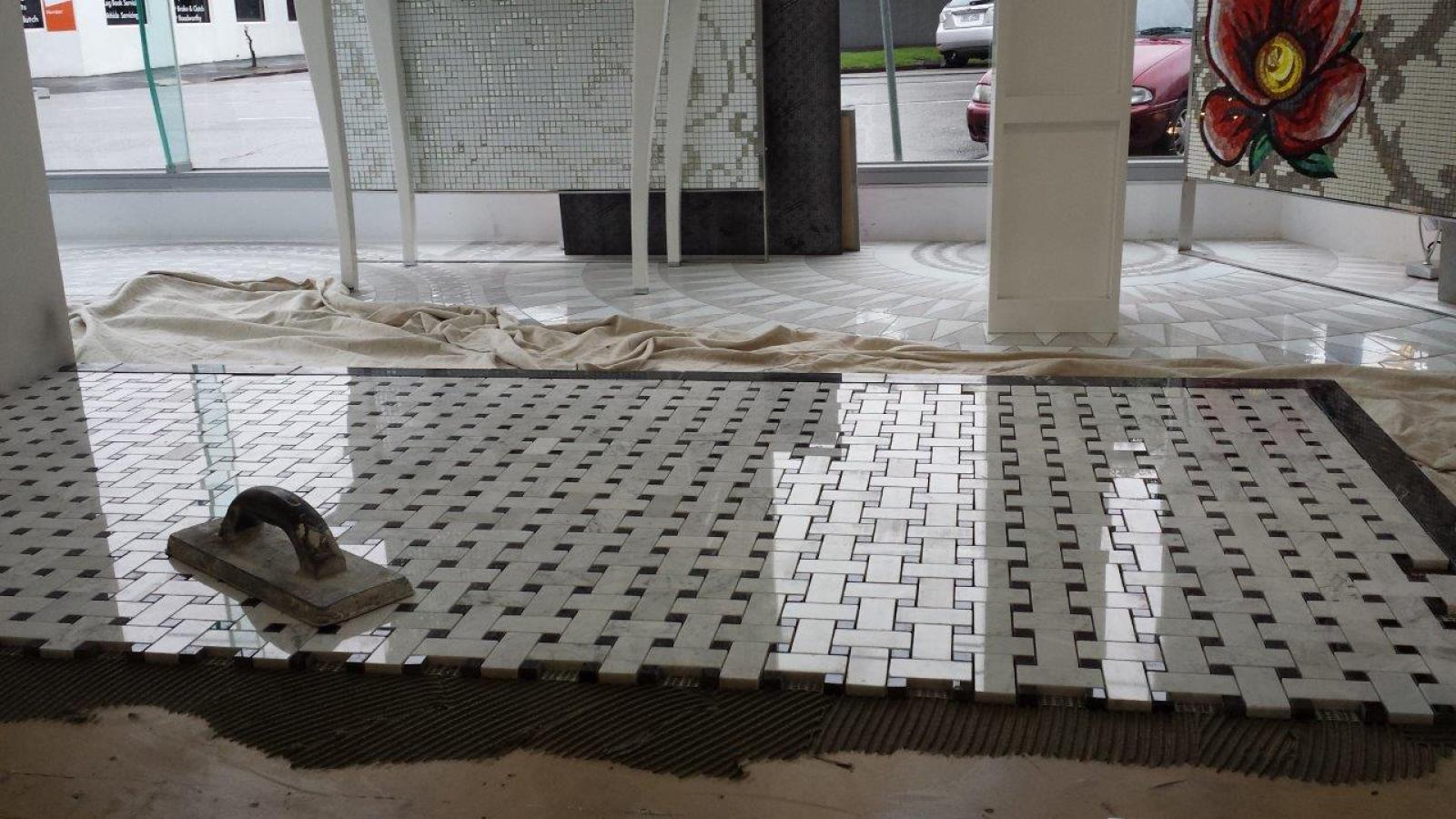 Bathroom floor under preparation with white tile levelling system and a trowel on the subfloor