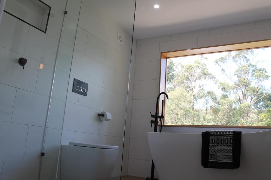 Modern bathroom with freestanding bath, matte black tapware and large window