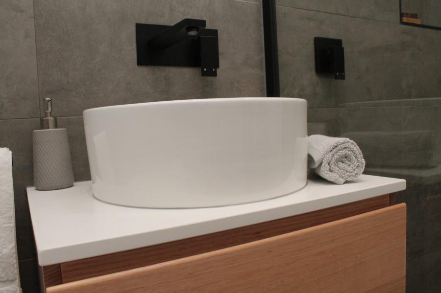 Modern bathroom vanity with white basin, timber cabinetry and matte black wall tapware