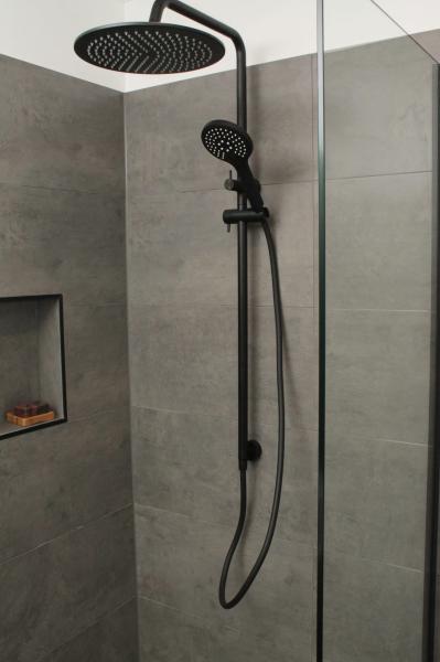 Matte black twin shower set in a grey tiled walk-in shower