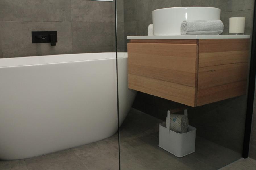 Modern bathroom with freestanding bath, timber floating vanity and vessel basin behind glass shower screen