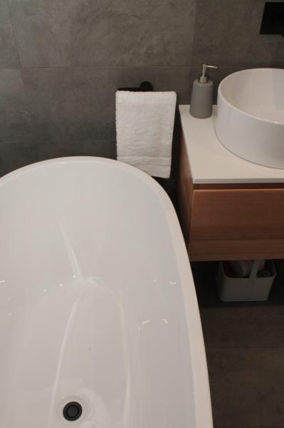 Modern bathroom with freestanding bath, timber vanity and round basin