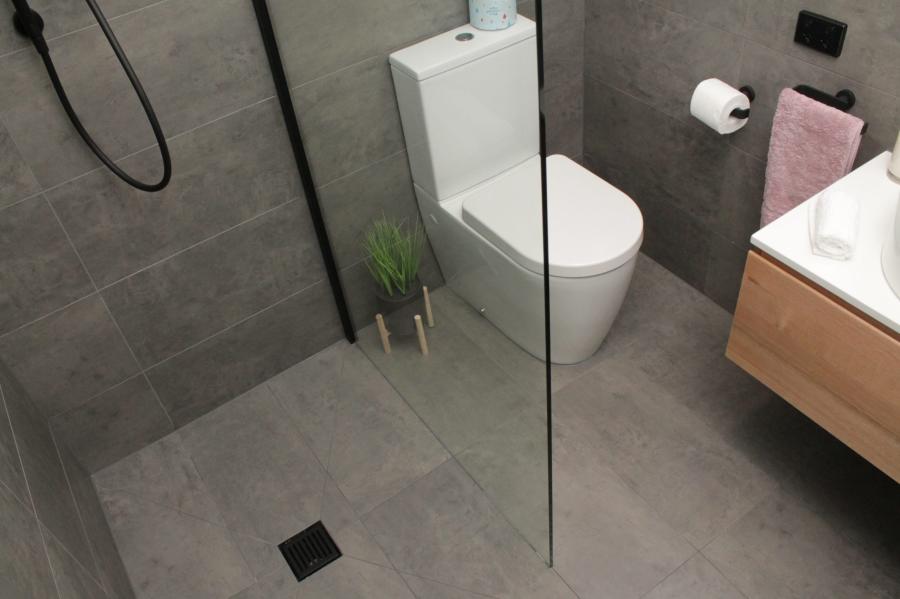 Modern grey tiled bathroom with walk-in shower, wall-hung vanity and close-coupled toilet