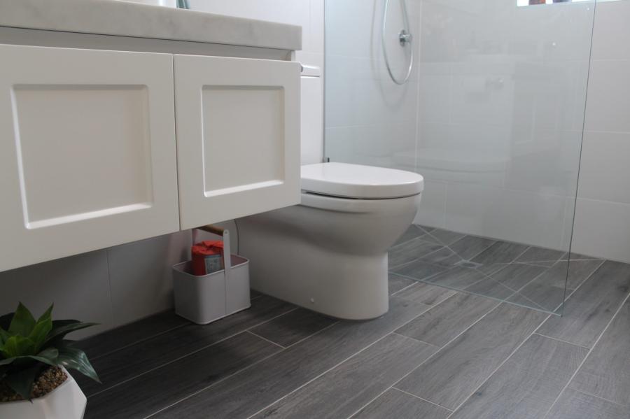 Modern bathroom with white wall-hung vanity, toilet and grey floor tiles
