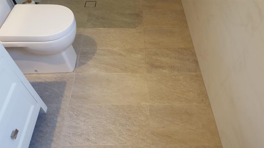 Modern bathroom floor tiling beside a white wall-hung toilet