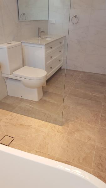 Modern bathroom with wall-hung vanity, toilet and frameless glass shower screen