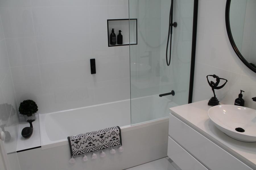 Modern white bathroom with bath, frameless shower screen and round basin vanity