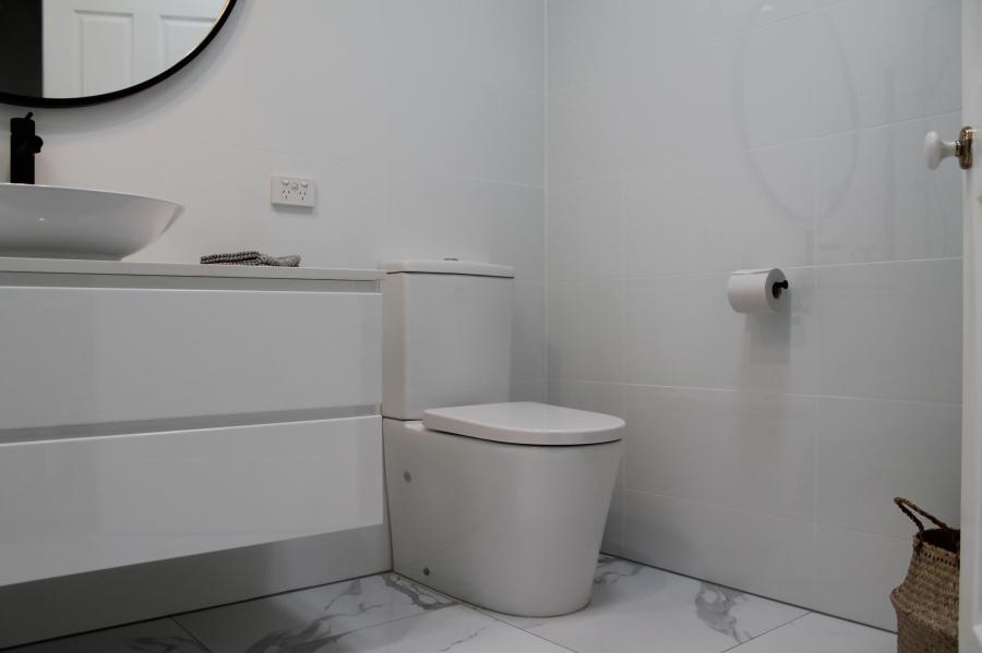 Modern white bathroom with floating vanity, basin and toilet