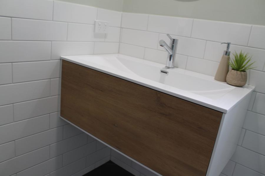 Floating timber-look bathroom vanity with white basin and chrome mixer tap