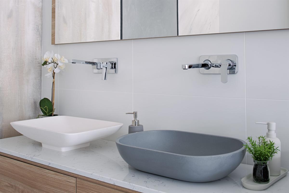 Modern double bathroom vanity with white and grey basin bowls beneath mirrored cabinetry