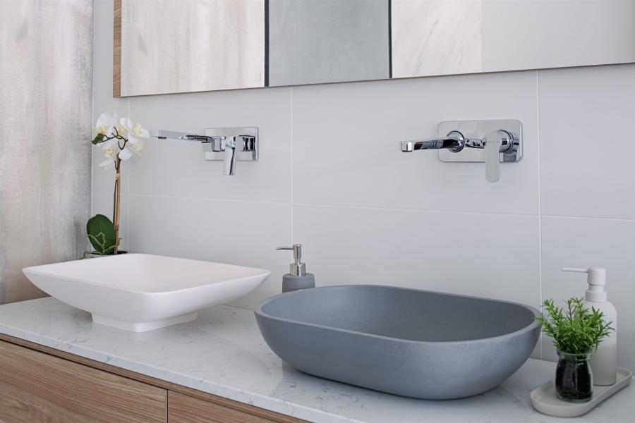 Modern double bathroom vanity with white and grey basin bowls beneath mirrored cabinetry