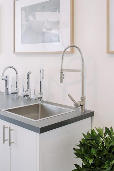 Compact white laundry cabinet with stainless steel sink and chrome mixer tap