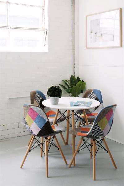 Small round table with four colourful chairs in a bright modern showroom corner
