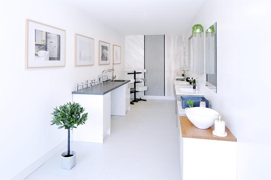 Bright white bathroom showroom with vanities, mirrors and display basins