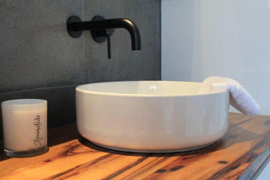 White round vessel basin on timber vanity with matte black wall tapware