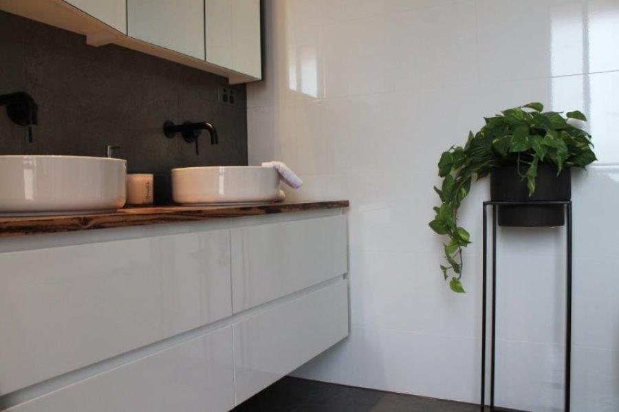Modern white bathroom vanity with twin basins, timber benchtop and potted plant