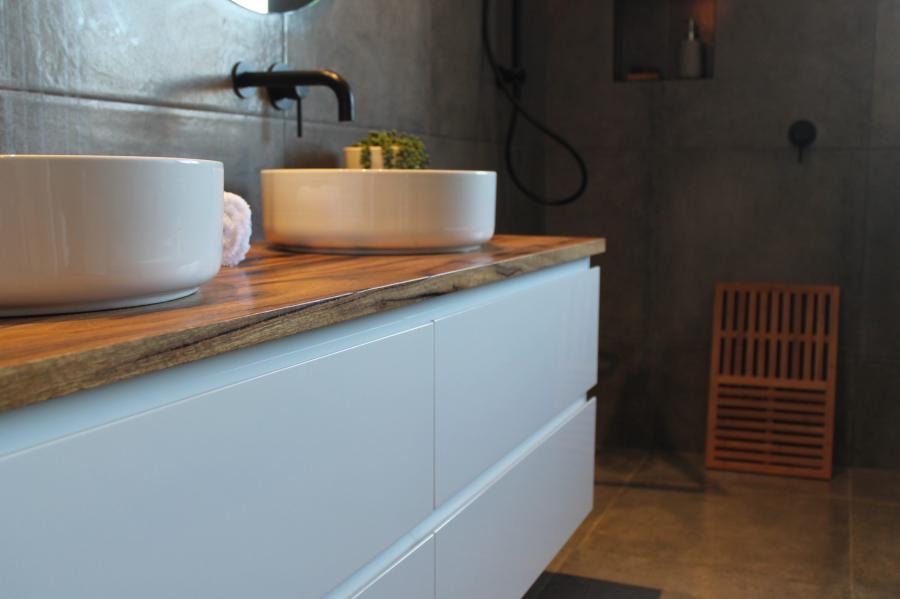 Modern bathroom vanity with double basins, timber benchtop and dark tiled walk-in shower