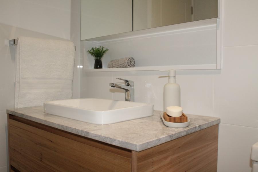 Modern bathroom vanity with stone benchtop, vessel basin and mirrored cabinet