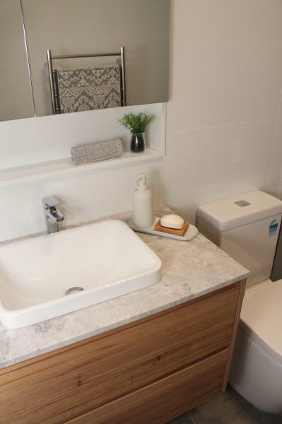 Modern bathroom vanity with stone benchtop, basin, mirror cabinet and toilet