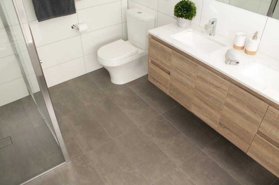 Modern bathroom with timber vanity, white basin, toilet and grey floor tiles