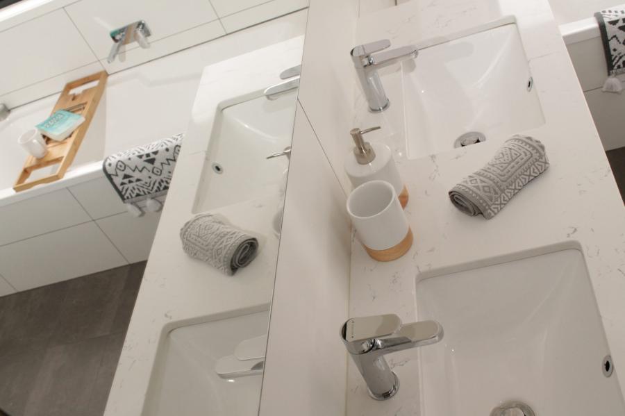 White modern bathroom vanity with basin, chrome tapware and rolled grey towels