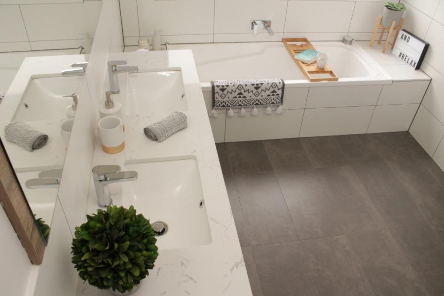 Modern white bathroom with floating vanity, bathtub and grey floor tiles