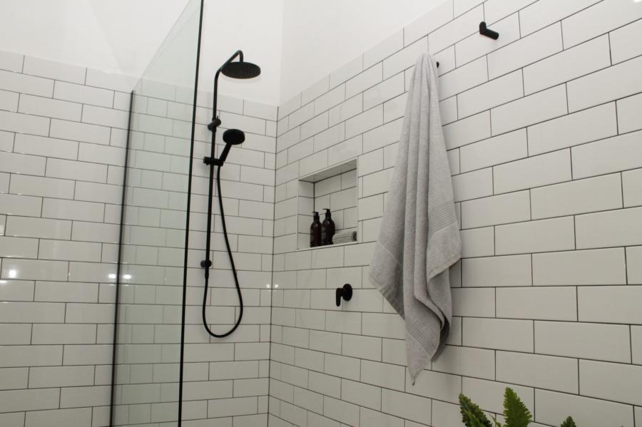 Modern bathroom shower with black tapware and white subway tiles