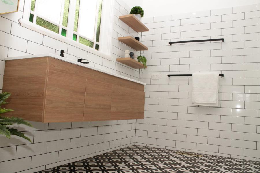 Modern bathroom with floating timber vanity, white subway tiles and patterned floor tiling