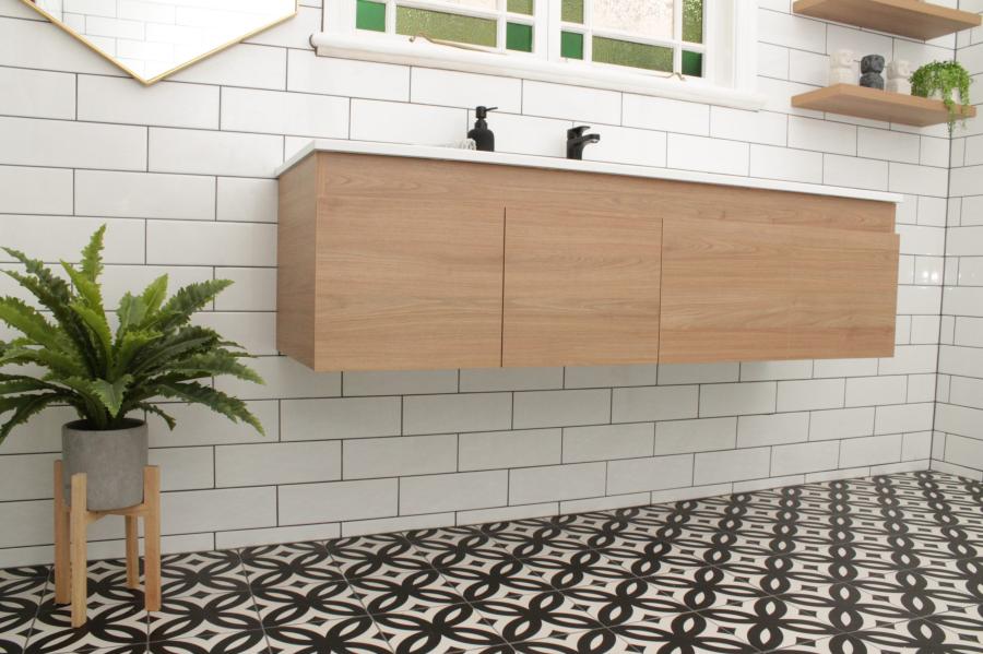 Floating timber bathroom vanity above patterned floor tiles
