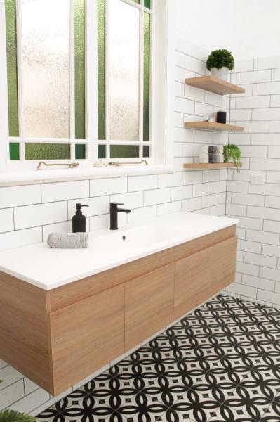 Modern bathroom vanity with black tap, white tiles and patterned floor