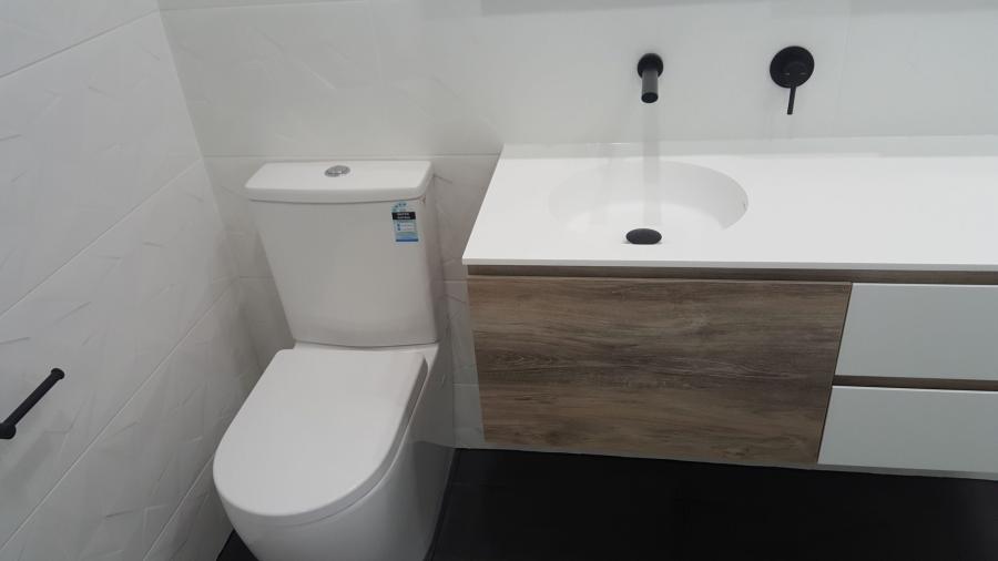 Modern bathroom vanity and toilet with timber-look cabinetry