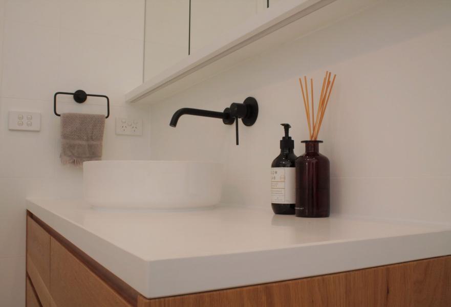 Modern bathroom vanity with black tapware and white stone countertop