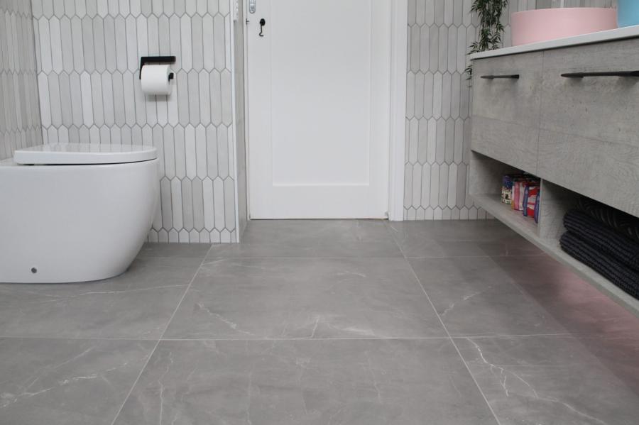 Modern bathroom with grey floor tiles, wall-hung vanity and freestanding toilet