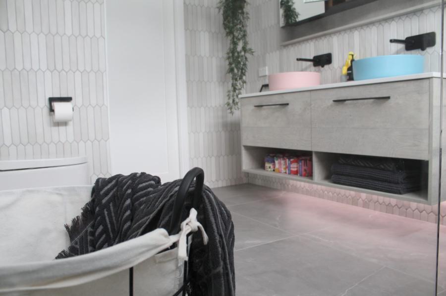 Modern white bathroom with freestanding bath, textured wall tiles and floating vanity