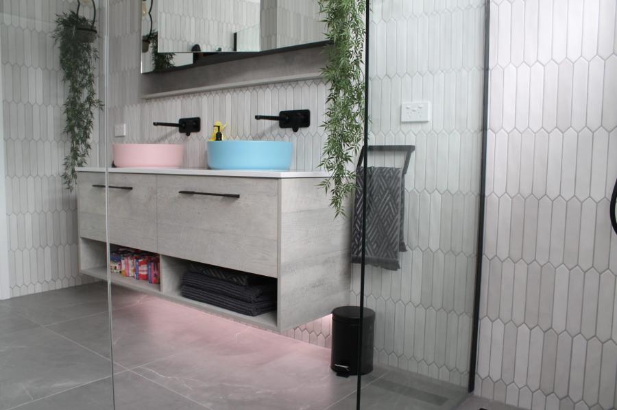 Modern bathroom with floating double vanity, pastel basins and frameless glass shower