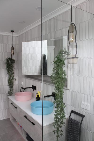 Modern bathroom with blue vessel basin, white vanity and walk-in glass shower
